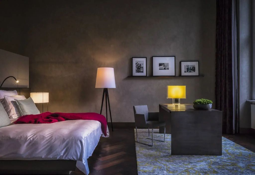 Geräumiges Zimmer mit Schreibtisch, moderner Beleuchtung und Kunstwerken