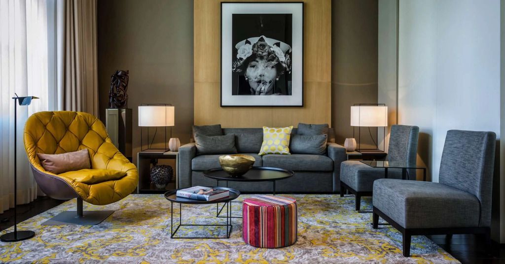 Wohnbereich mit grauem Sofa und farbenfrohen Akzenten in der Suite