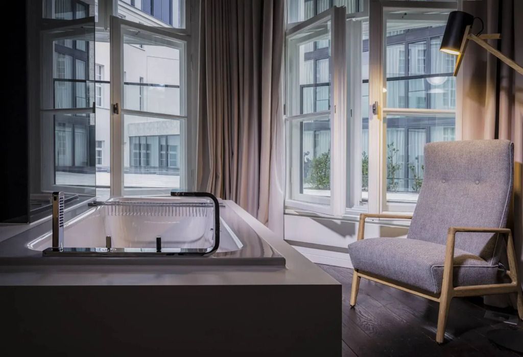 Sitzbereich in einer Suite mit Blick auf Innenhof und Badewanne