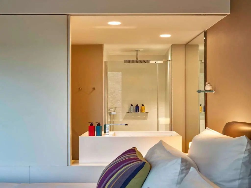 Modernes Badezimmer mit gläserner Duschwand, Waschtisch und dekorativen Elementen