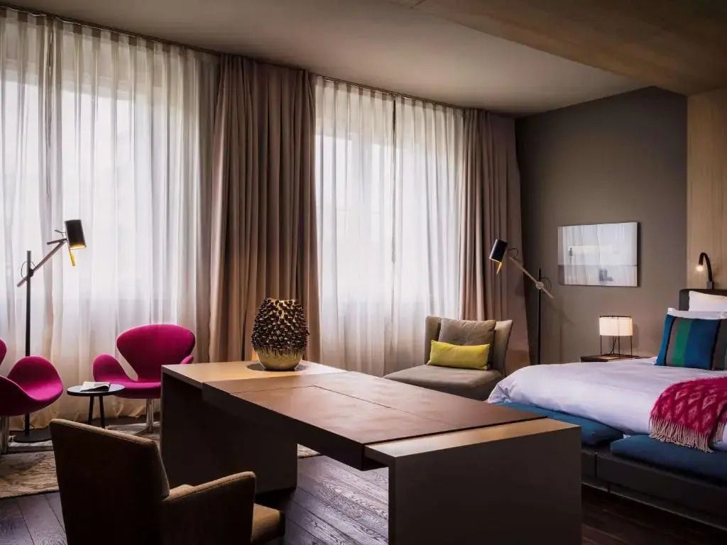 Gemütliches Ambiente mit modernen Möbeln und großem Fenster in einer Suite