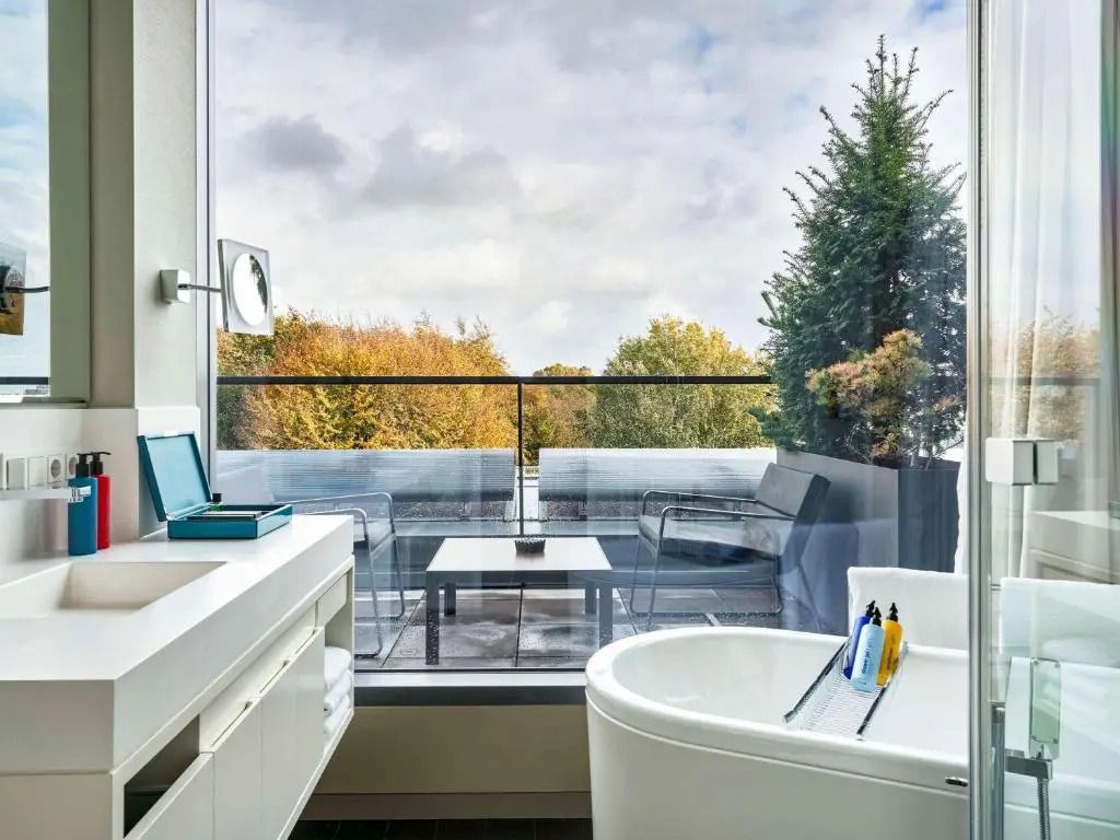 Badezimmer mit freistehender Badewanne und Blick auf einen Balkon