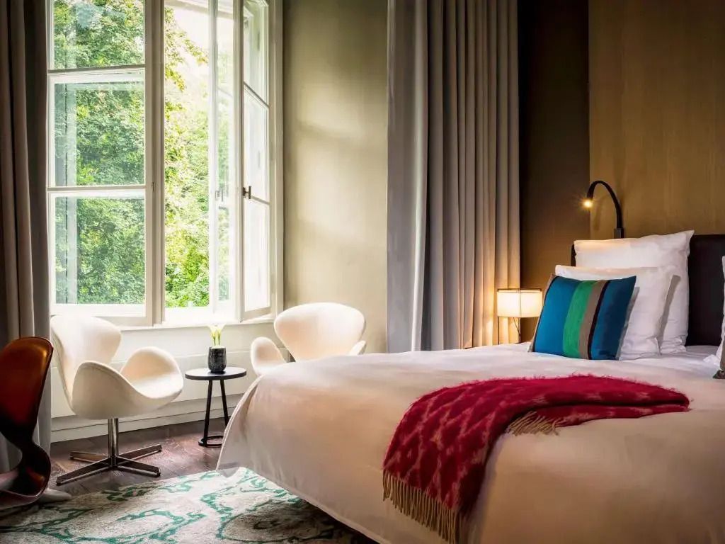 Modernes Doppelzimmer mit elegantem Interieur und großen Fenstern mit Gartenblick