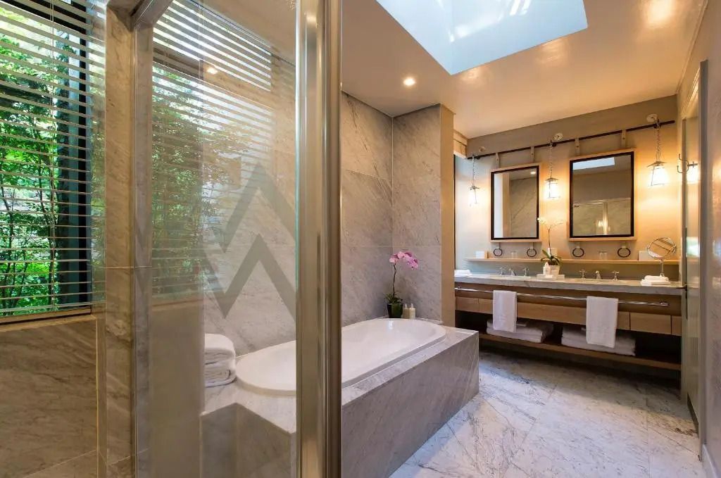 Luxuriöses Badezimmer mit Badewanne und zwei eleganten Waschtischen.