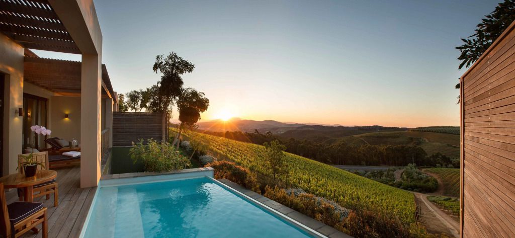 Infinity-Pool mit Sonnenuntergang und Blick auf die Weinberge.