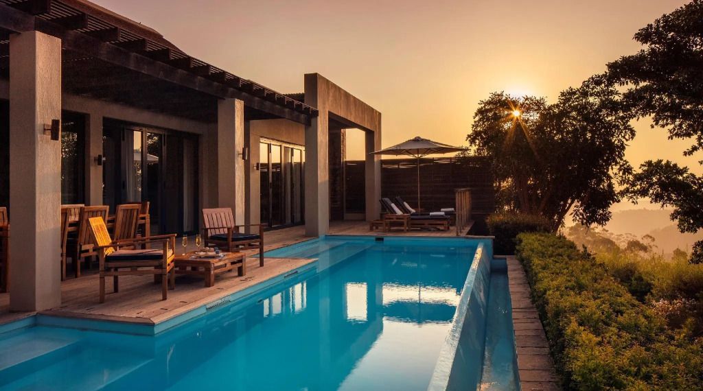 Infinity-Pool bei Sonnenuntergang neben einer modernen Suite im Hotel.