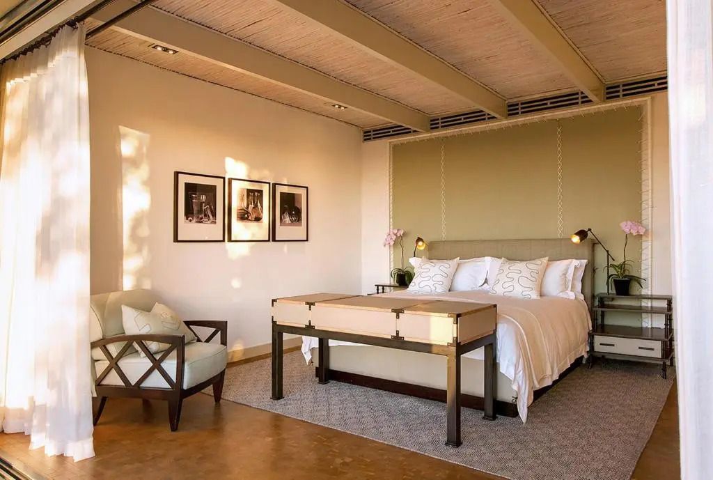 Geräumiges Schlafzimmer mit gemütlichem Sessel und Kunstwerken.