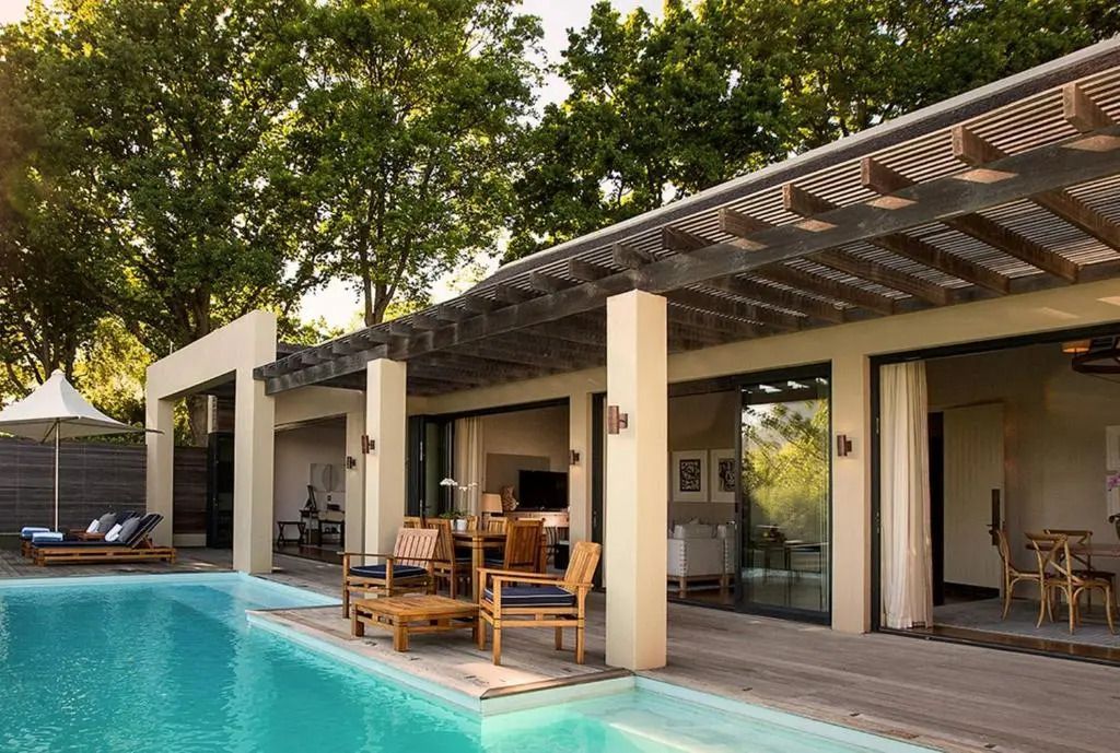 Moderne Villa mit Pool und stilvoller Architektur inmitten von Bäumen.