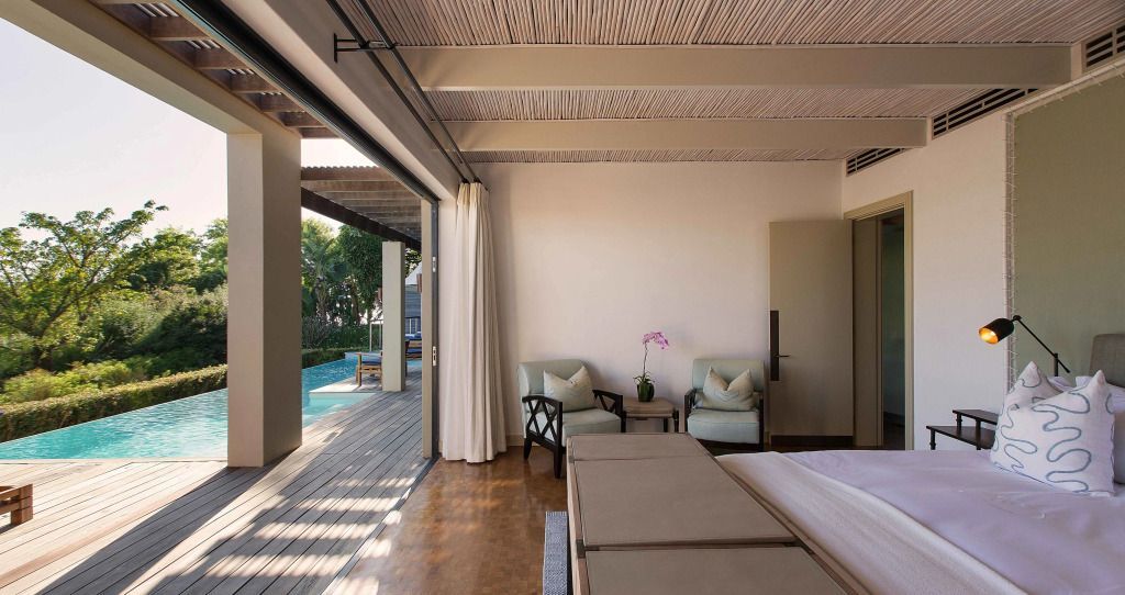 Schlafzimmer angrenzend an Terrasse mit Poolblick