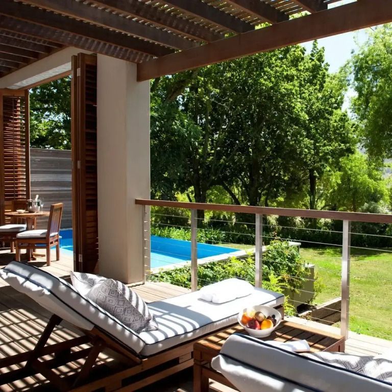 Terrasse mit Liegestühlen und Blick auf Garten und Pool