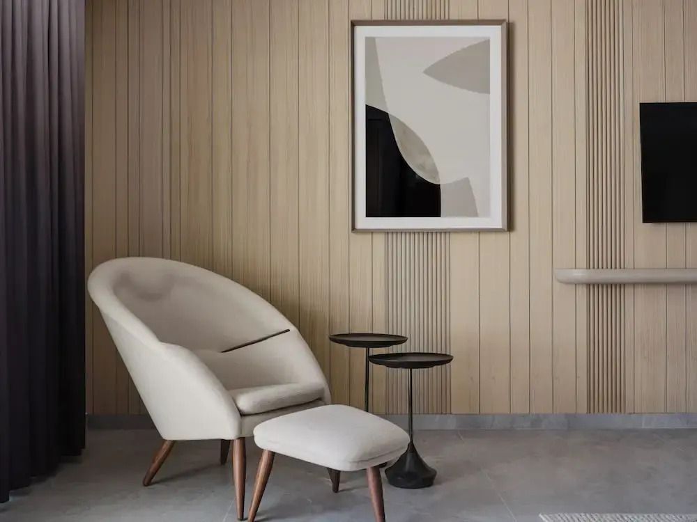 Minimalistische Sitzecke mit Sessel und Kunst an der Wand