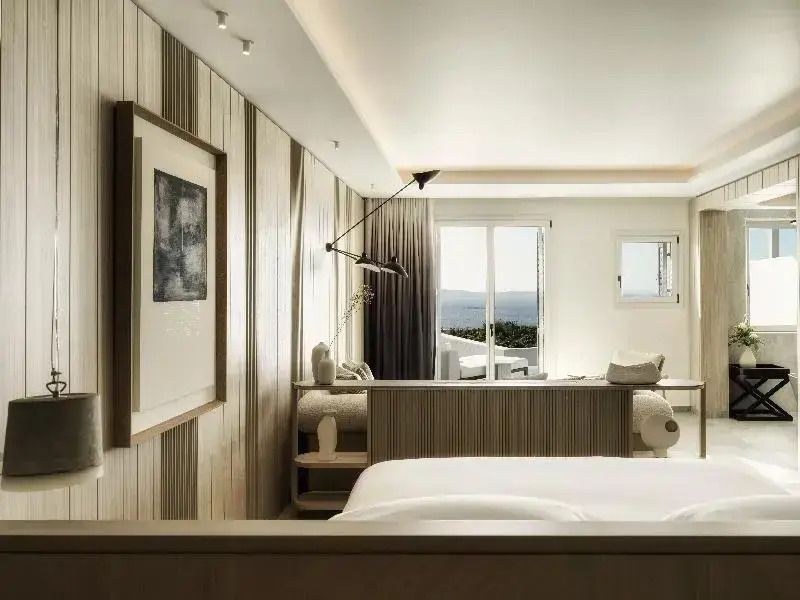 Geräumiges Zimmer mit Doppelbett und kunstvoller Dekoration im Deos Mykonos.