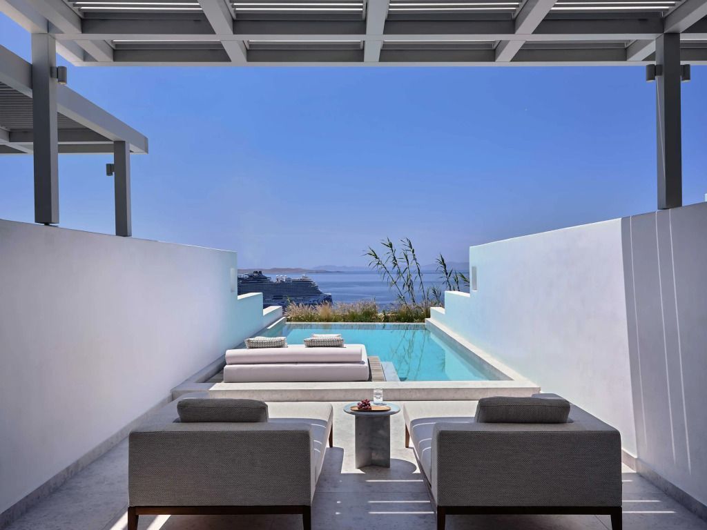 Privater Pool mit Meerblick umrahmt von eleganten Sonnenliegen