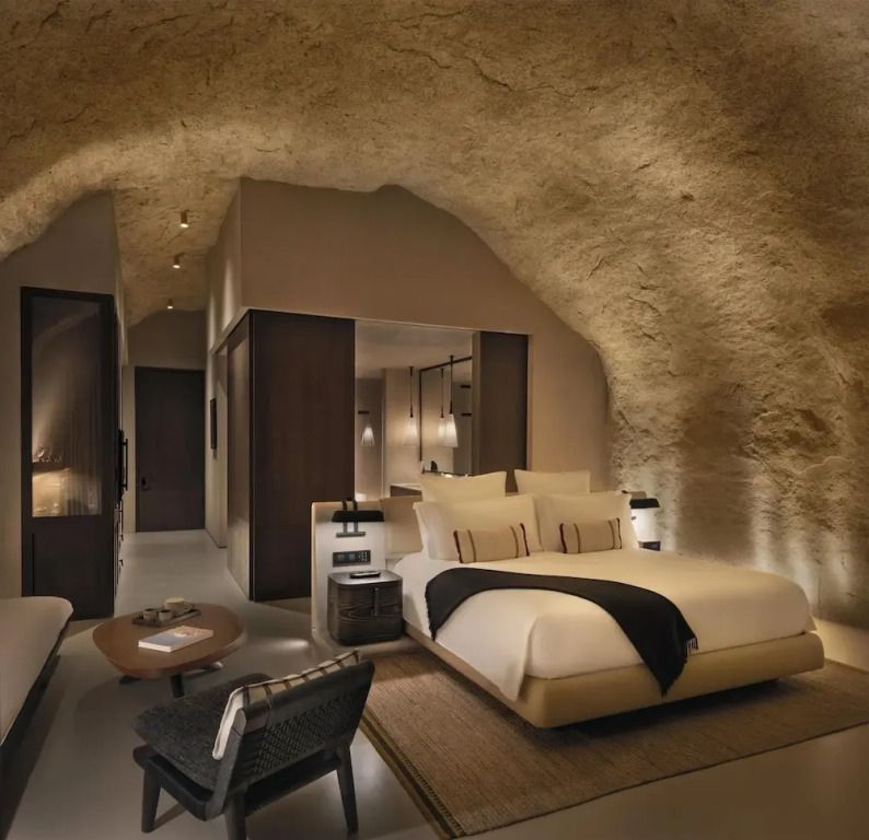 Luxuriöses Schlafzimmer einer Suite mit natürlicher Höhlenarchitektur und modernem Design.