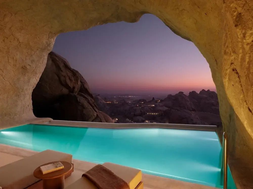 Infinity Pool mit Blick auf die Wüstenlandschaft bei Dämmerung.