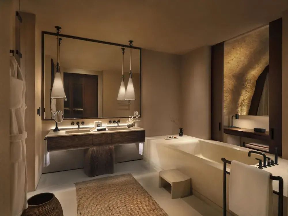 Modernes Badezimmer einer Suite mit großer Badewanne und stilvoller Beleuchtung.