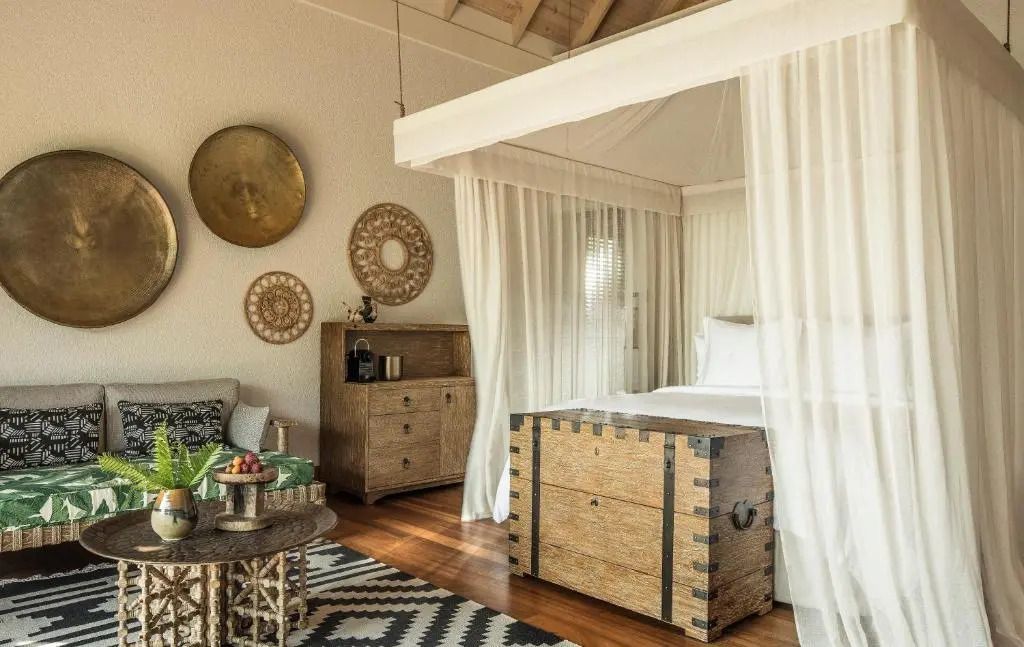 Gemütliches Schlafzimmer in einer Pool Villa mit Himmelbett und rustikalen Möbeln