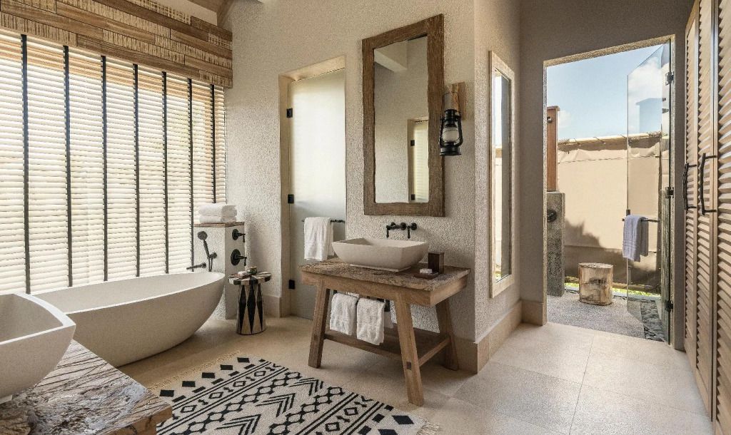 Stilvolles Badezimmer mit freistehender Badewanne und Holzdetails in der Villa