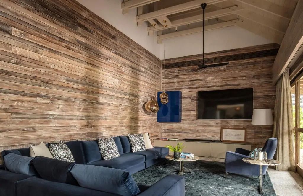 Stilvoll eingerichteter Wohnbereich mit blauen Sofas und Holzwänden in der Präsidenten Villa