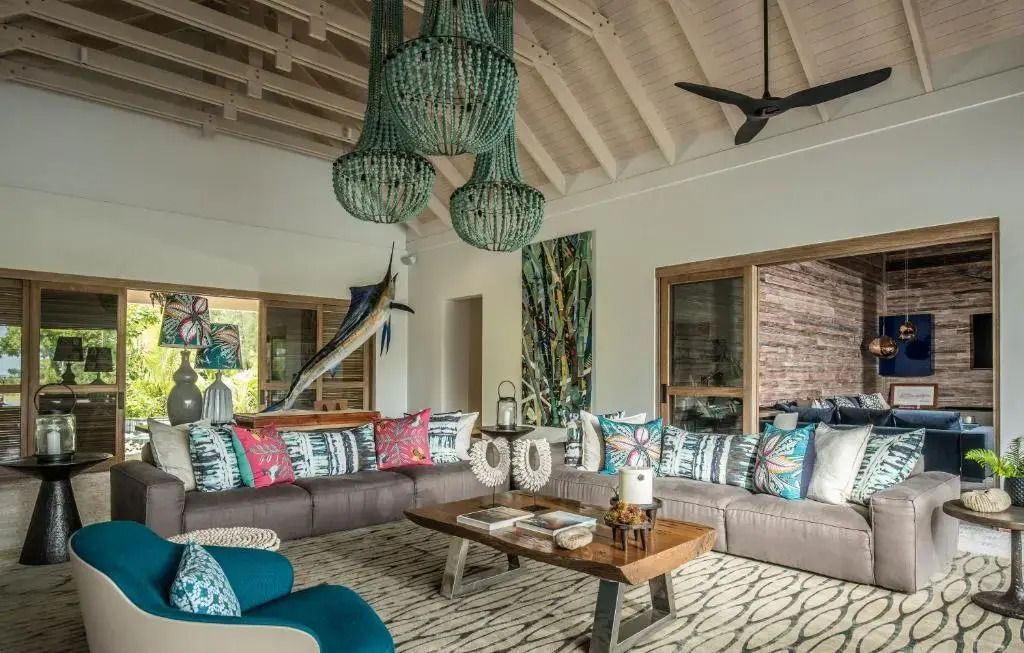 Geräumiger Wohnraum mit exotischen Dekorationen und hohen Decken im Four Seasons Resort