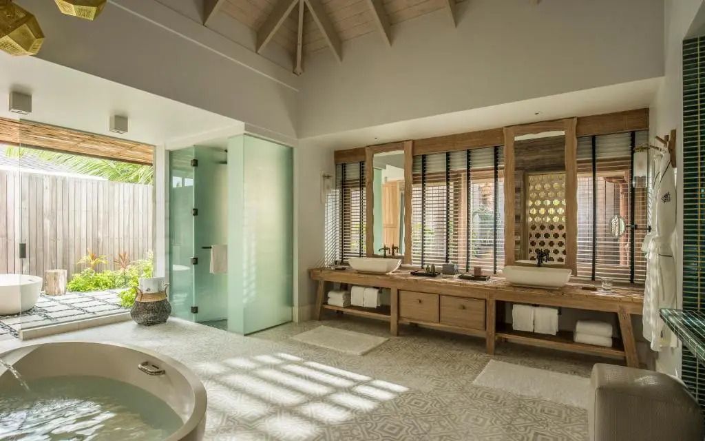 Luxuriöses Badezimmer mit Doppelwaschbecken und Badewanne im Four Seasons Resort Seychelles