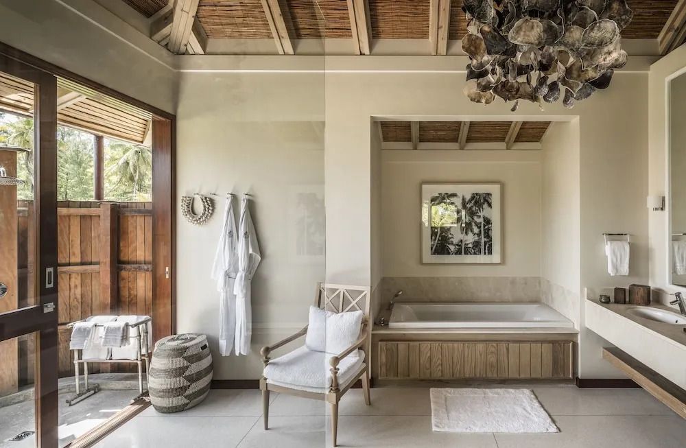 Helles Badezimmer mit Badewanne und dekorativen Elementen im Resort-Stil.