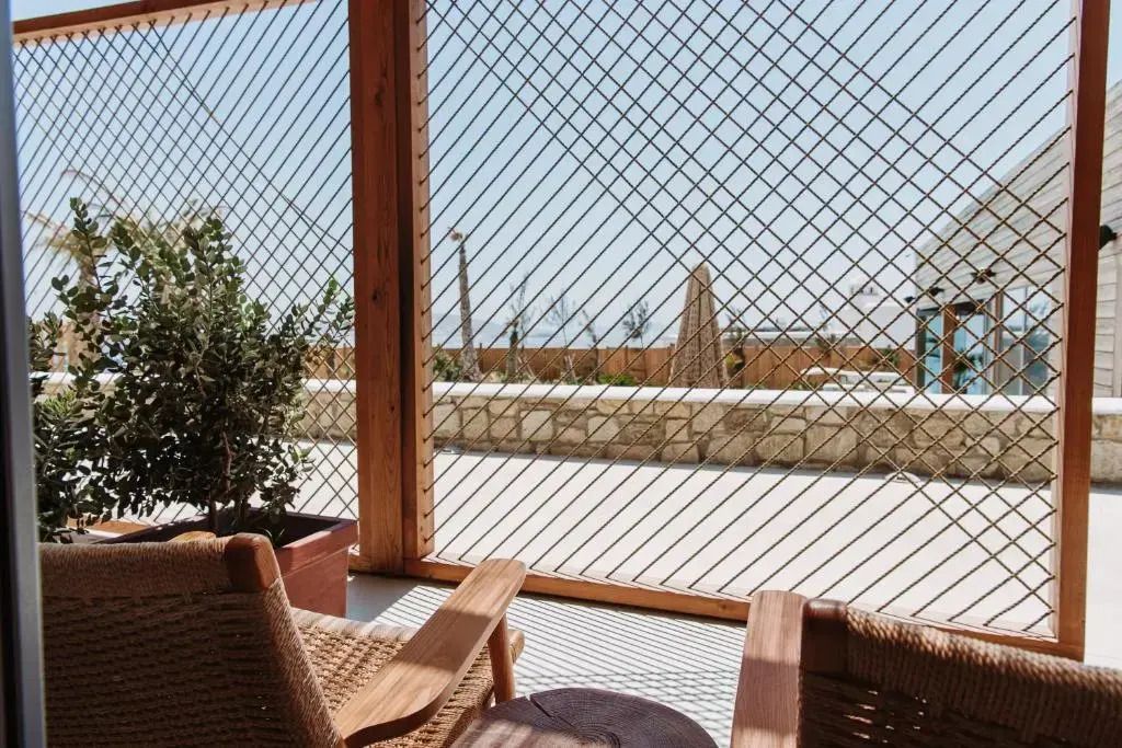 Sitzbereich auf einer Terrasse mit Blick durch Holzgitter.