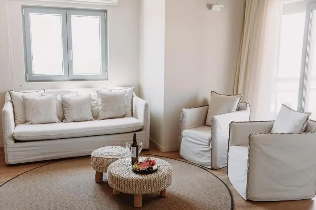 Helles Wohnzimmer mit Sofas und Sessel in warmen Tönen