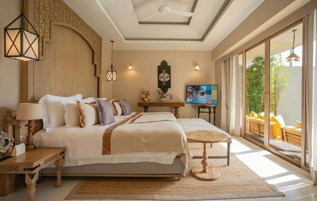 Luxuriöses Schlafzimmer mit großem Doppelbett, dekorativen Kissen und TV.