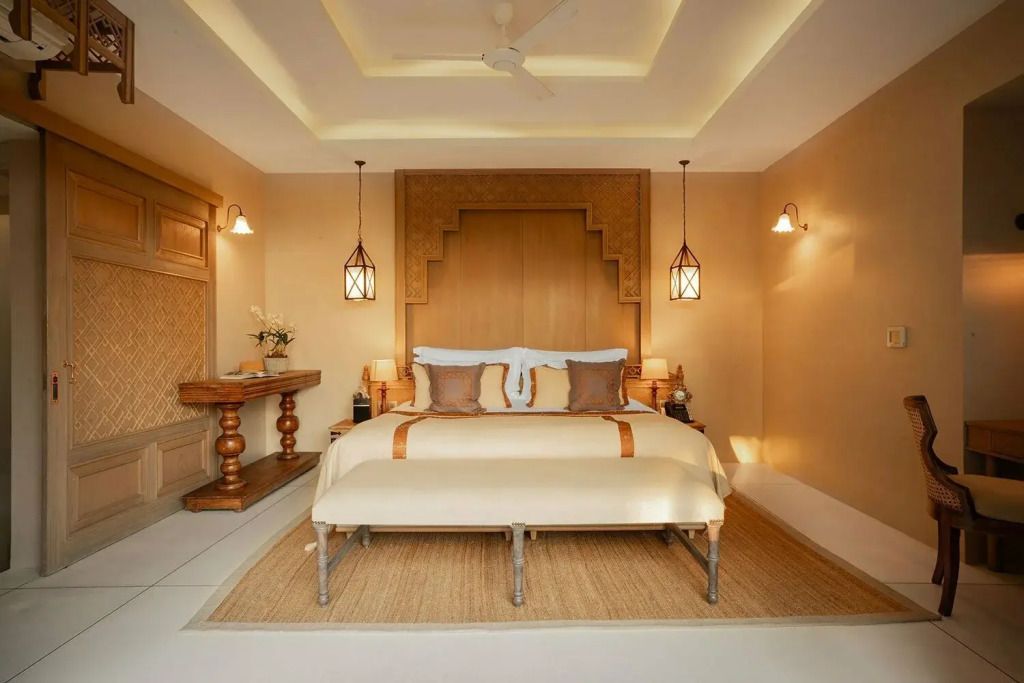 Großes Doppelbett in elegantem Schlafzimmer mit warmer Beleuchtung.