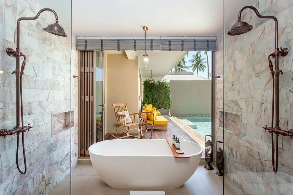 Modernes Badezimmer mit freistehender Badewanne und Blick auf den Pool.