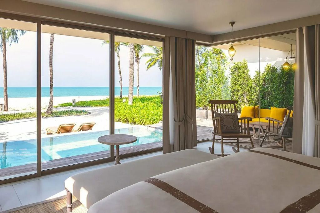 Helles Zimmer mit Fensterfront zum Meer und Zugang zu privatem Pool im Grünen