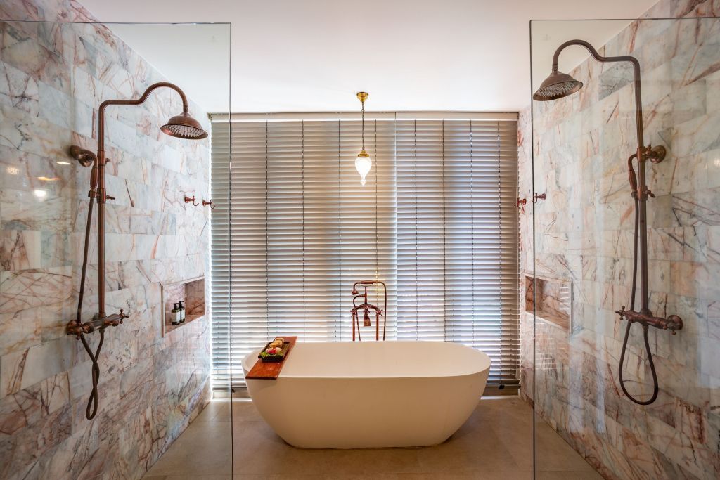 Modernes Badezimmer mit freistehender Badewanne und stilvoller Steinverkleidung
