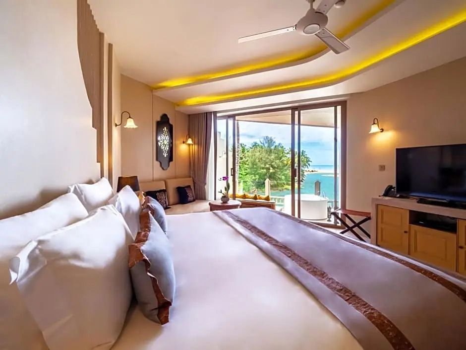 Geräumige Junior-Suite mit Jacuzzi und Blick auf das Meer durch große Fenster.