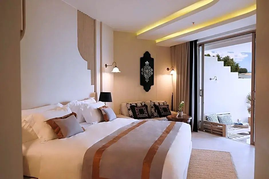 Elegante Gestaltung der Junior-Suite mit gemütlichem Sitzbereich und stilvollen Lampen.