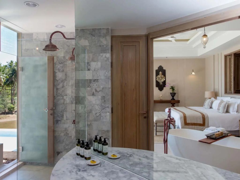 Badezimmer mit edlen Marmorelementen, Sichtschutz und großzügigem Spiegel