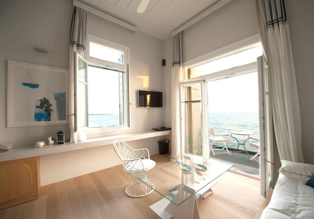 Helles Wohnzimmer mit Meerblick und einem modernen Sessel auf einem Holzboden