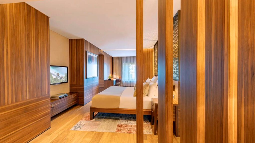 Geräumiges Schlafzimmer der Superior Suite mit TV und modernen Holzmöbeln