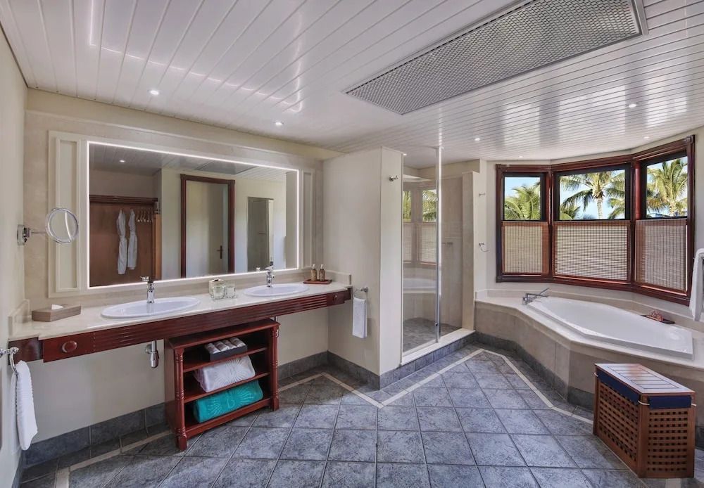 Großzügiges Badezimmer mit Doppelwaschbecken und Gartenblick in der Junior-Suite