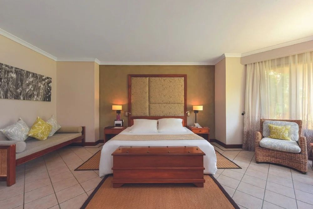 Luxuriöses Hauptschlafzimmer mit stilvollem Holzmobiliar und warmen Farben