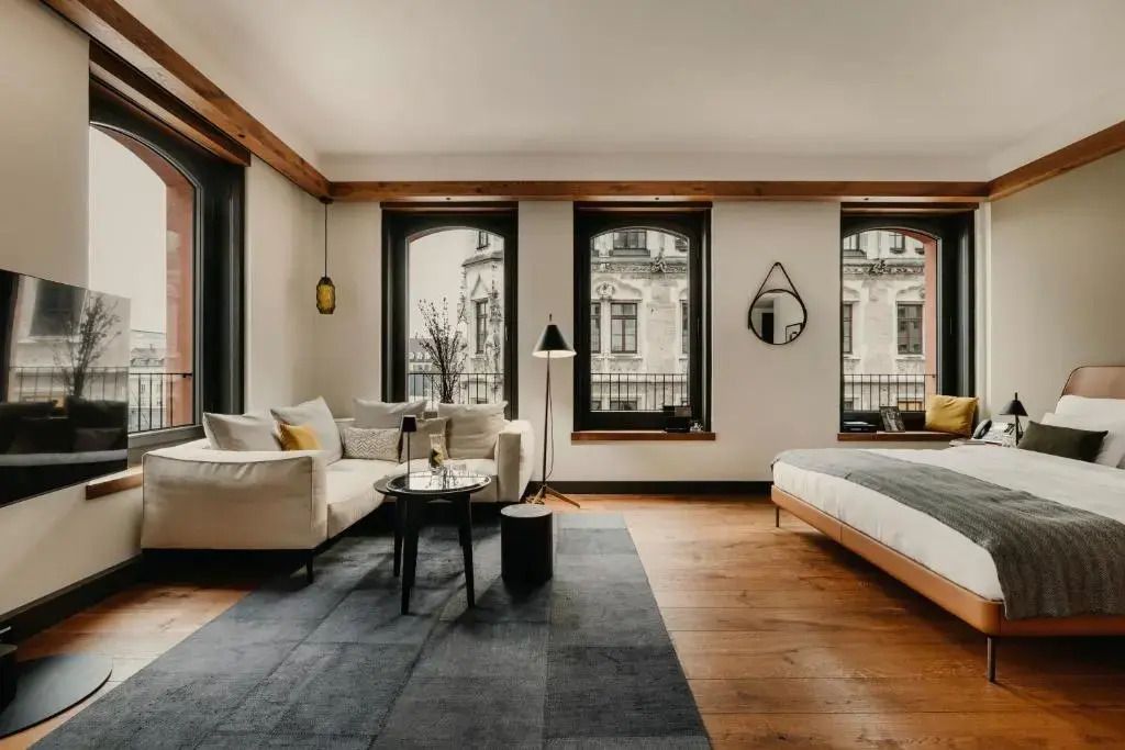 Elegantes Wohnzimmer der Deluxe Junior-Suite mit großen Fenstern und moderner Einrichtung.