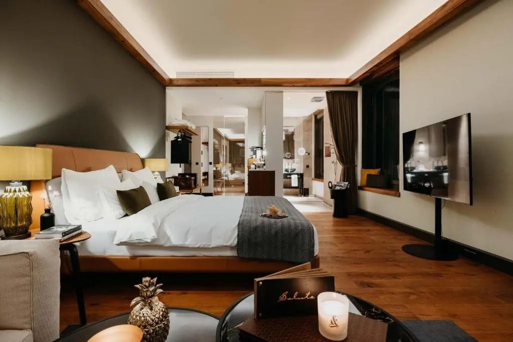 Komfortables Schlafzimmer in der Deluxe Junior-Suite mit stilvollem Design und Beleuchtung.