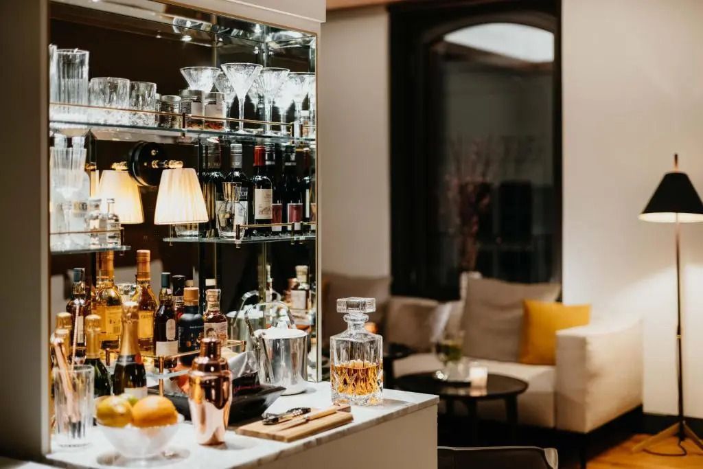 Stilvolle Bar-Ecke der Deluxe Junior-Suite mit erlesenen Spirituosen und gemütlichem Sitzbereich.