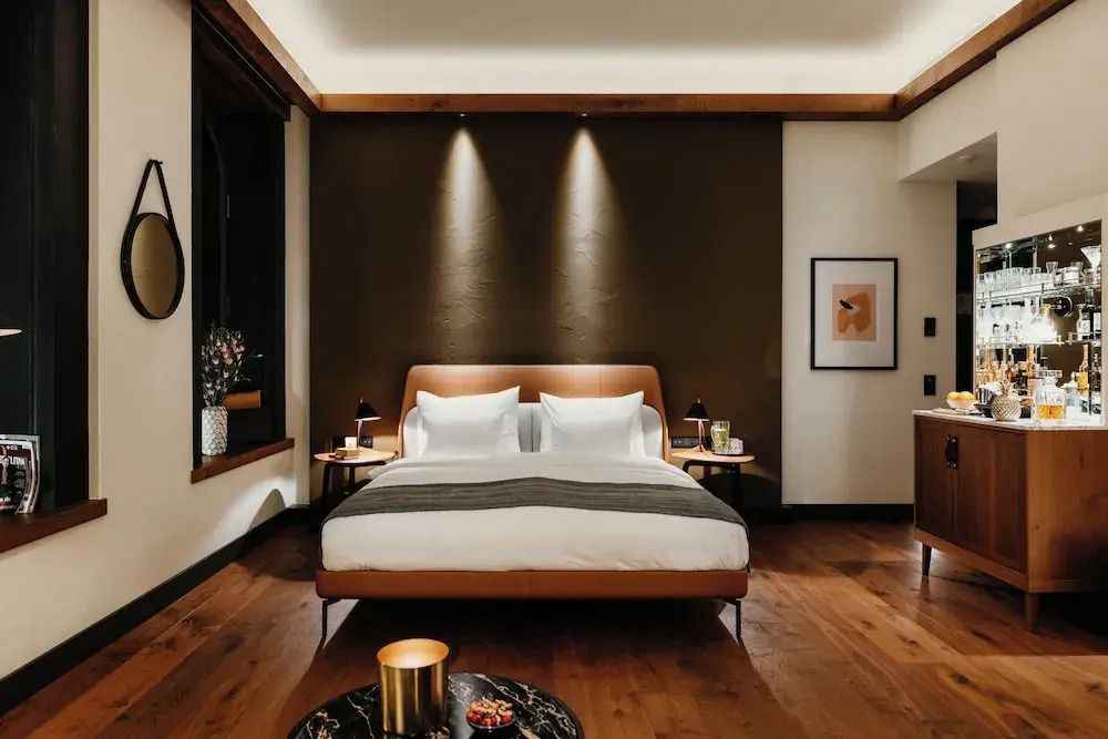 Schlafbereich mit elegantem Doppelbett und stimmungsvoller Beleuchtung.