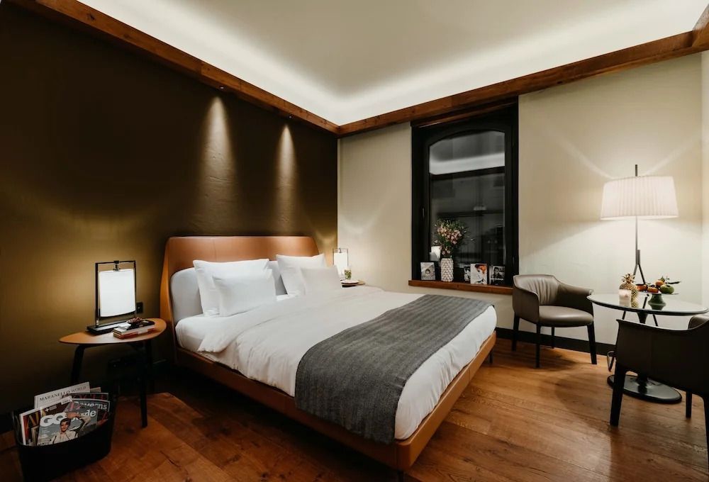 Elegantes Doppelzimmer mit modernen Lichtelementen und Holzboden