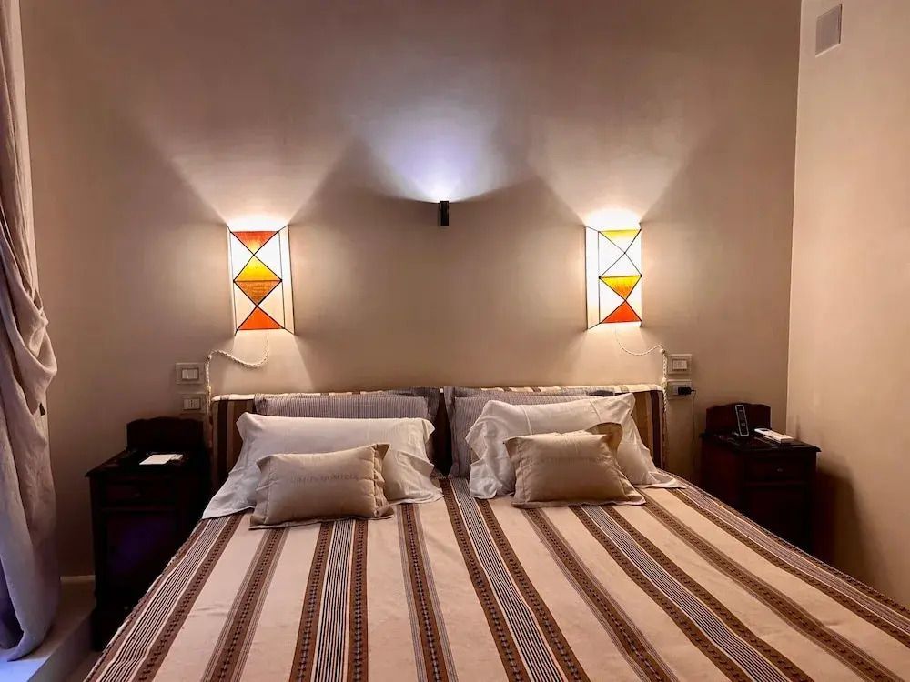 Gemütliches Doppelbett mit dekorativen Nachttischlampen und Kissen
