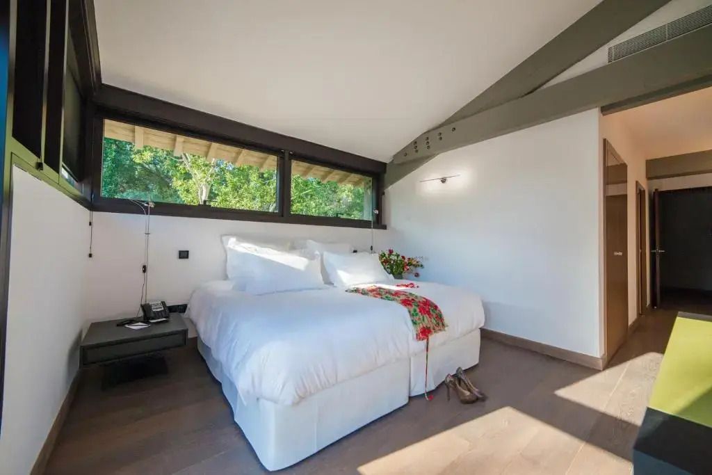 Gemütliches Schlafzimmer mit Doppelbett und grüner Aussicht