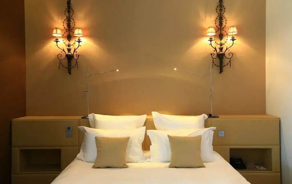 Luxuriöses Doppelbett in einer Junior-Suite mit stilvollen Wandlampen