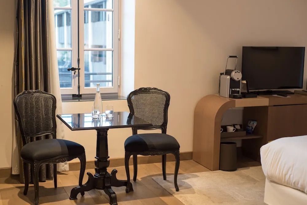 Sitzecke mit zwei Stühlen, Tisch und Blick auf Fenster im Hotelzimmer