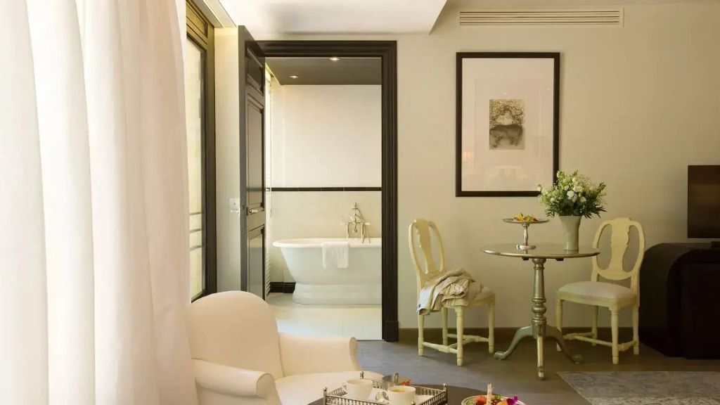 Helles Wohnzimmer mit Blick ins luxuriöse Badezimmer der Prestige Suite